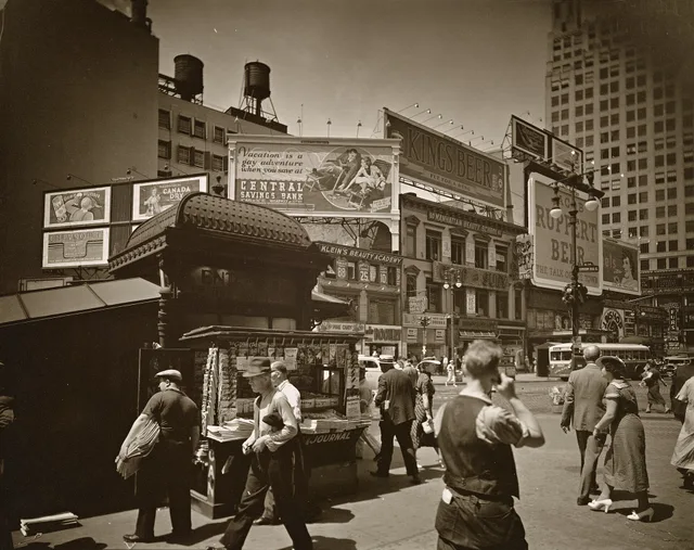 * Code: I.B.; III.B.1. Men and women hurry past newstand outside uptown subway entrance, street beyond is lined with businesses topped with large billboards. Citation/Reference: CNY# 151. Out of home advertising: a 2027 planning checklist